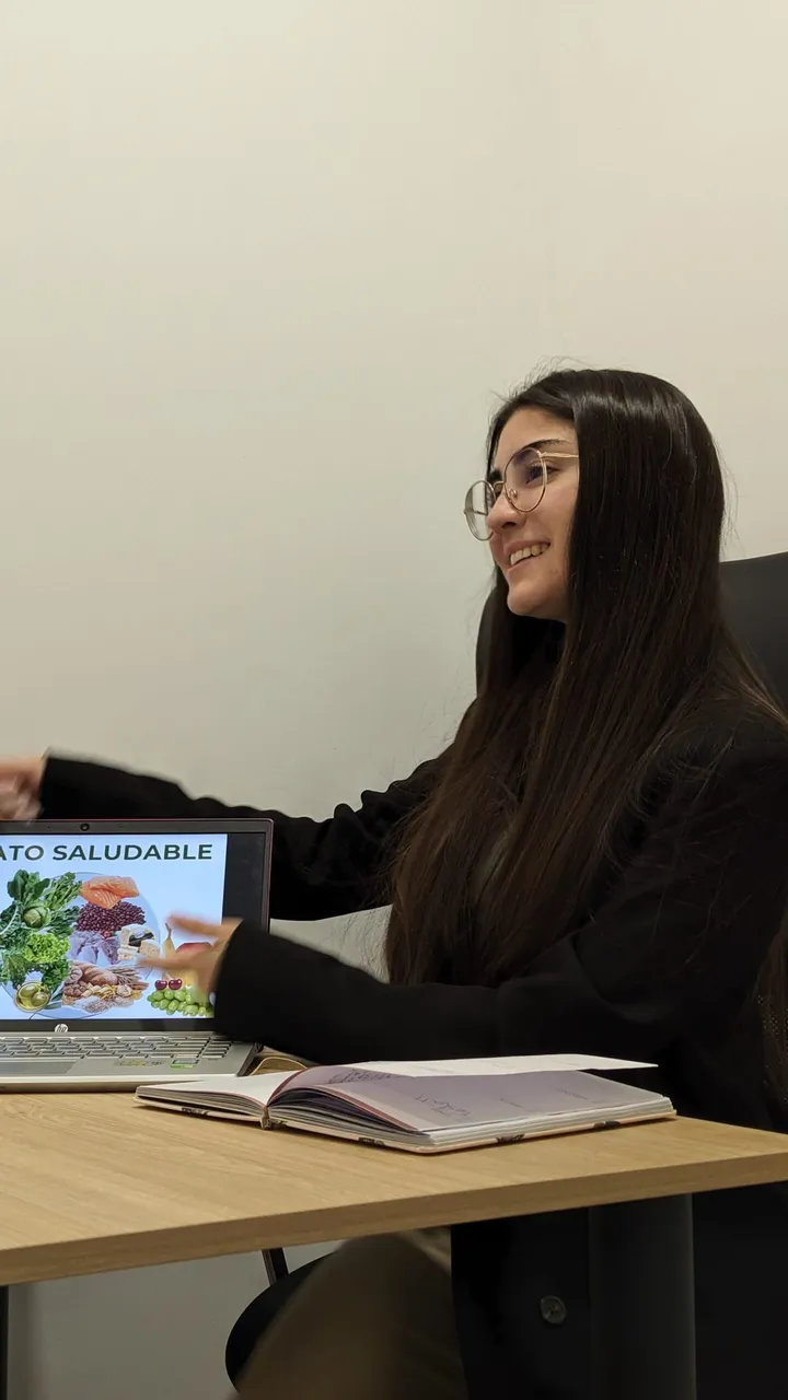 Iris Gómez en su consulta, revisando un plan de alimentación con una paciente